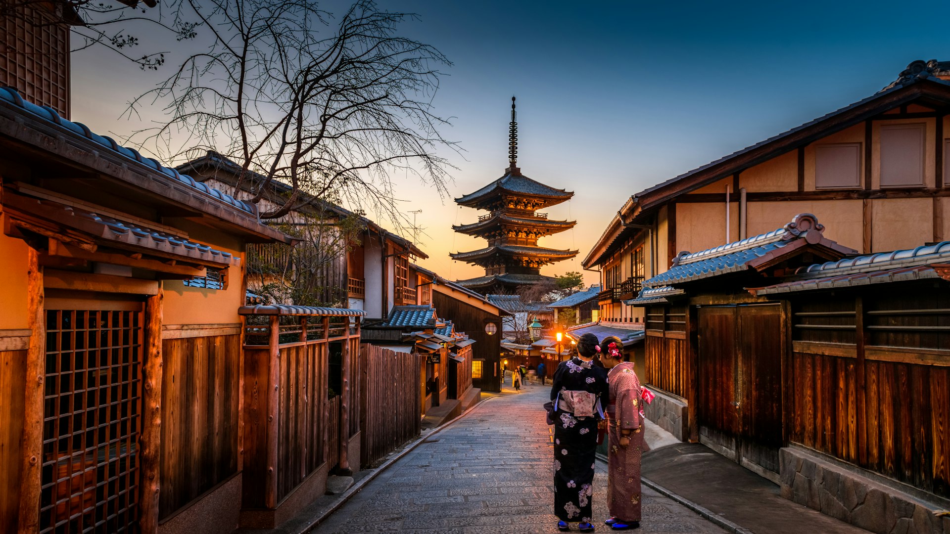 Kyoto'nun tarihi sokağında kimonolu iki kadın, arkada Yasaka Pagodası